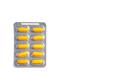 A small round mass of solid medicine to be swallowed whole. Yellow red pills in blisters on a white background.