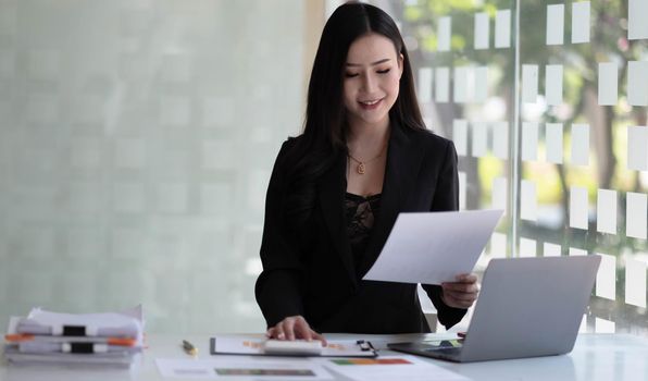 Portrait of Asian young female working on laptop at office.