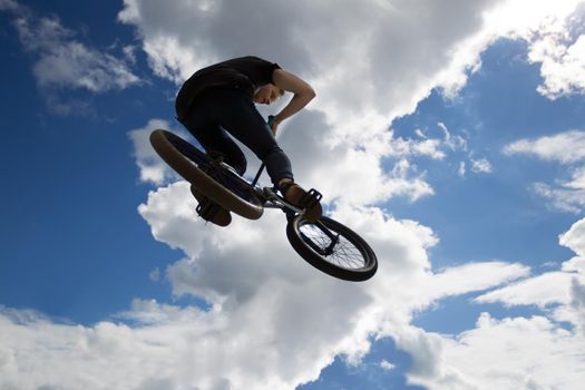 Extreme cycling.A man on an extreme bicycle against the sky. Leap into the sky