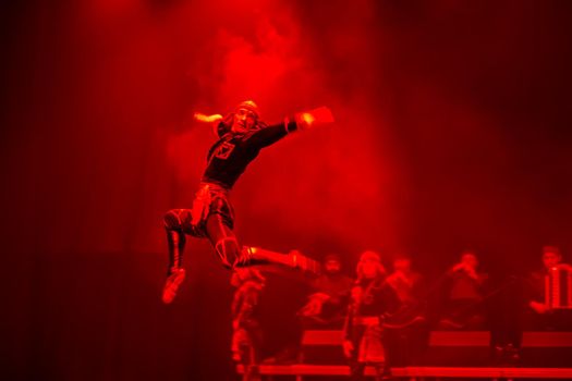 Belarus, Gomel, February 27, 2018. Concert hall. Speech of the national Georgian ballet Sukhishvili.The Georgian dancer jumped high while performing the dance on stage with a red light