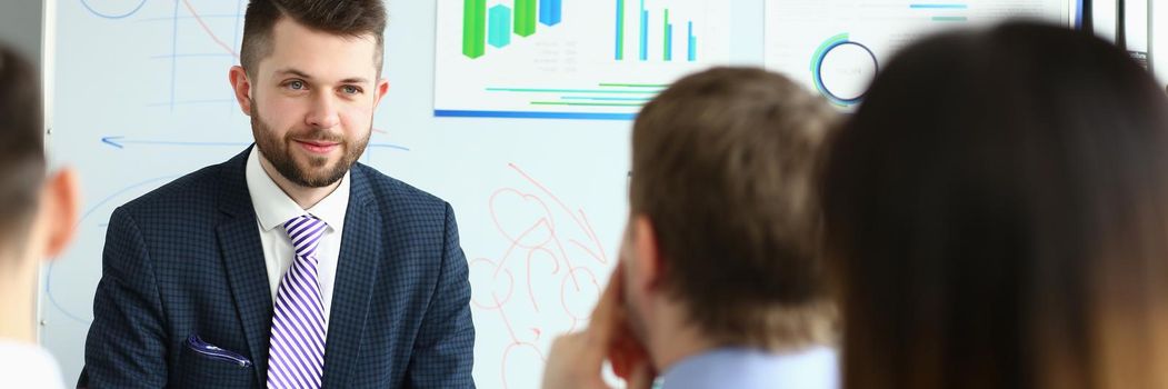 Portrait of handsome and cheerful person. Chief executive officer talking with business colleagues about new project. Worker sitting in conference room. Company and business meeting concept