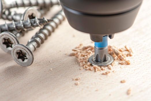 Manufacture of wooden furniture. Driving a screw into a piece of furniture. Assembling wooden furniture close-up.