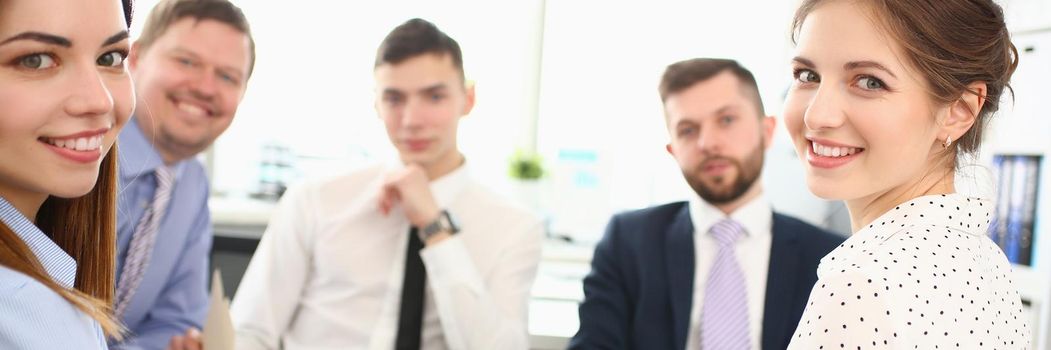 Portrait of smart colleagues discussing important biz topic that can determine corporation future. Smiling manager looking at camera with joy. Company meeting concept