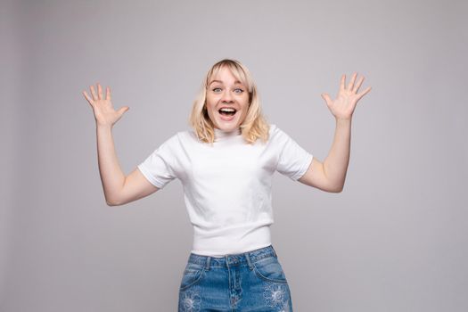 Waist up portrait of surprised beautiful girl with nice long hair, perfect makeup and fashion manicure. She is looking at camera with astonishment. Isolated