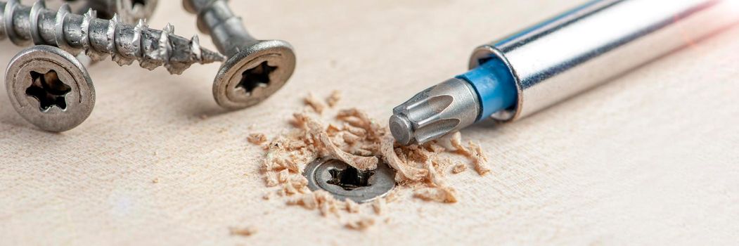 Manufacture of wooden furniture. Driving a screw into a piece of furniture. Assembling wooden furniture close-up.