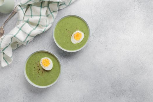 Spinach cream soup with boiled egg top view