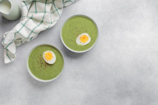 Spinach cream soup with boiled egg top view