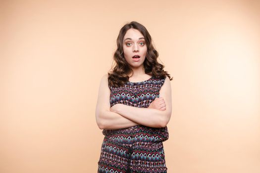 Waist up portrait of surprised beautiful girl with nice long hair, perfect makeup and fashion manicure. She is looking at camera with astonishment. Isolated on dark background