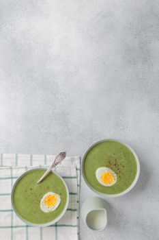 Spinach cream soup with boiled egg top view