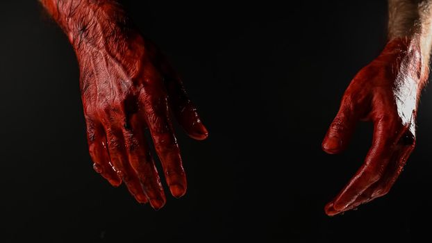 Male bloody hands on a black background