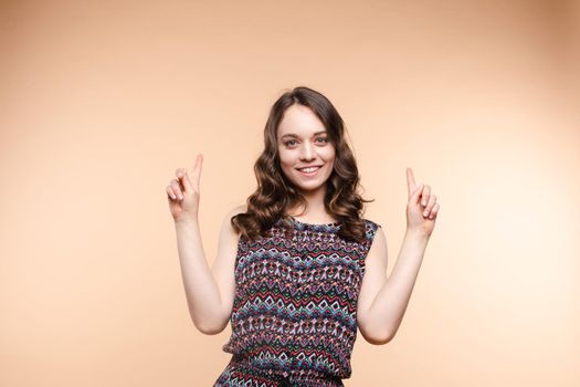 Cropped view from front of happy woman pointing at outfit with fingers. Cheerful girl laughing and posing on isolated backround. Concept of casual style.