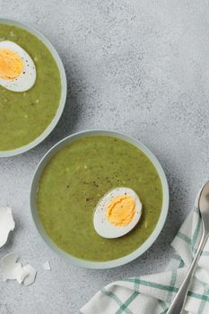 Spinach cream soup with boiled egg top view