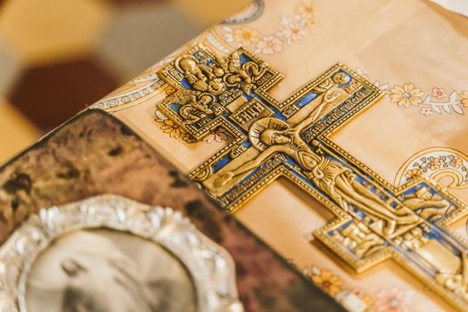 Orthodox cross and holy book with picture of Jesus Christ on the table in church. Orthodox faith. Equipment for praying. Pray for people life. Pray to god