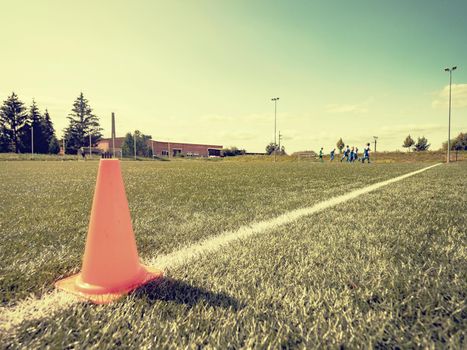 Orange border cone.  Soccer training court line and cone equipment on green field for football sports.