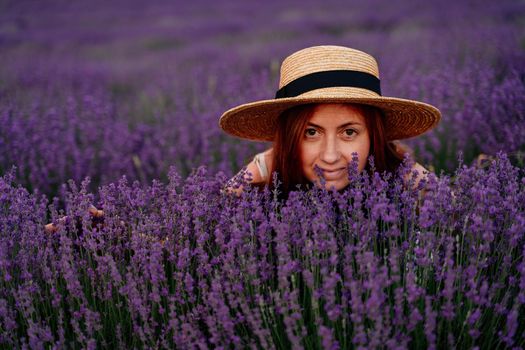 Close up portrait of a happy young woman in a dress on blooming fragrant lavender fields with endless rows. Bushes of lavender purple fragrant flowers on lavender fields