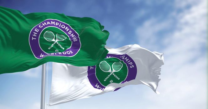 London, UK, April 2022: flags with the The Championships Wimbledon logo waving in the wind. Wimbledon Championships is a major tennis tournament scheduled in late June each year