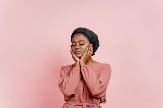 Muslim young woman weared in traditional dress and scarf touches her face and relax. Relaxation and meditation with yoga.