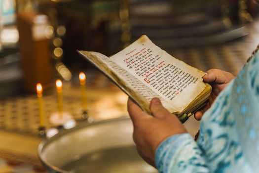 Holy book opened in priest hands in church. Priest reads pray. Orthodox faith. Equipment for praying. Pray for people life. Pray to god