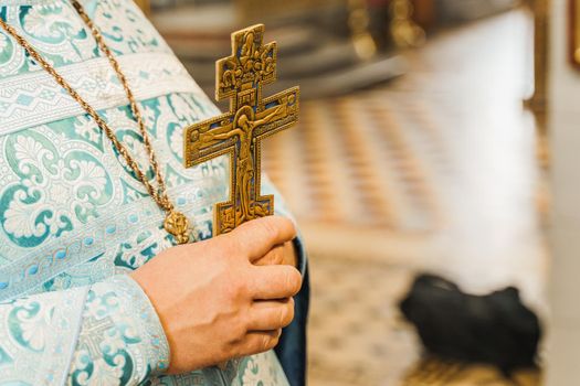 Holy father in his robe with a golden cross in his hands in church. Orthodox tradition and faith. Equipment for praying. Pray for people life. Pray to god
