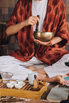 Tibetan singing bowl in the hands of a man during a tea ceremony.