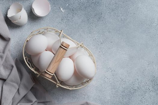 Spring time, easter holidays, white eggs in a basket gray table