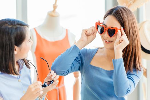 girl teen trying and buying cute fancy heart shaped sunglasses happy enjoy shopping with friends