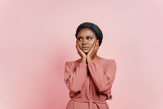 Muslim young woman weared in traditional dress and scarf touches her face and relax. Relaxation and meditation with yoga.