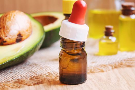 Avocado and avocado oil on wooden background. Selective focus.food