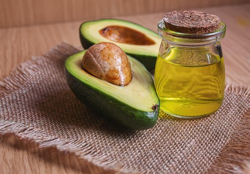 Avocado and avocado oil on wooden background. Selective focus.food