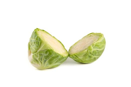 Fresh green Brussels sprouts on a white background. Brussels sprouts cut in half casts a shadow on white isolate.