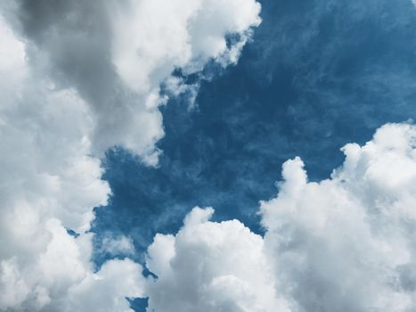 Cumulus clouds diagonally against a dark blue sky with free space