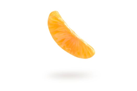 A piece of mandarin isolated on a white background, falling casting a shadow. Individual segments of tangerine slices, for inserting into a project or design