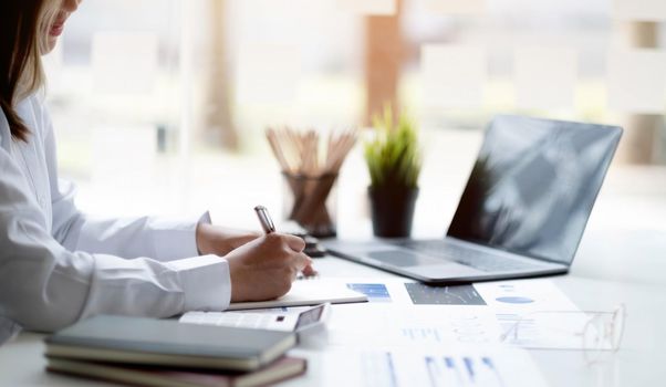 Close up. Businesswoman hand taking notes working at a office..