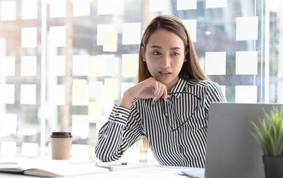 Young Asian businesswoman is happy to work at the modern office using a tablet..