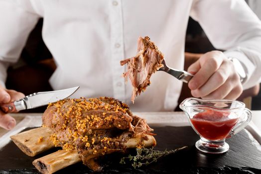 Barbecue ribs with mustard grains and sauce on black slate plate on white wooden table