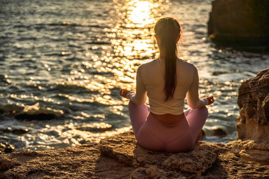 Young woman practicing yoga outdoors. Harmony and meditation concept. Healthy lifestyle.