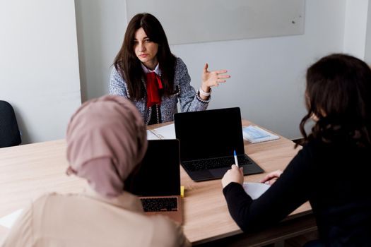 Foreign school private study with a school girl. Teacher explain grammar of native language using laptop. Prepearing to exam with tutor.