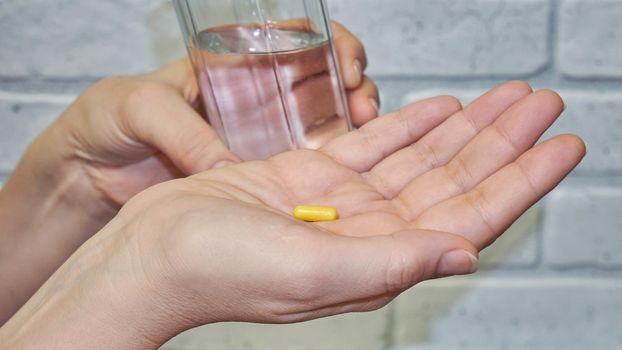 Woman taking medicine with a glass of water