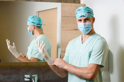Doctor puts sterile medical gloves on his hands and looks in camera. Protect of pandemic of coronavirus covid 19 in Spain. Hygiene for hands