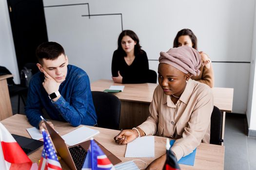 Foreign school private study with a school girl. Teacher explain grammar of native language using laptop. Prepearing to exam with tutor. English, British, German and Poland flags in front.