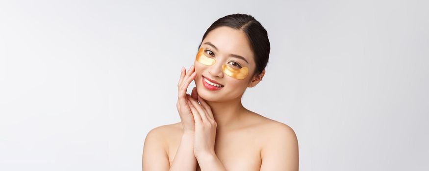 Asian beauty teenager woman care her skin with gold eye masks patches under eyes.