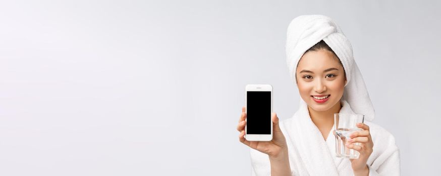 Healthy young beautiful woman drinking water, beauty face natural makeup with holding mobile phone, isolated over white background