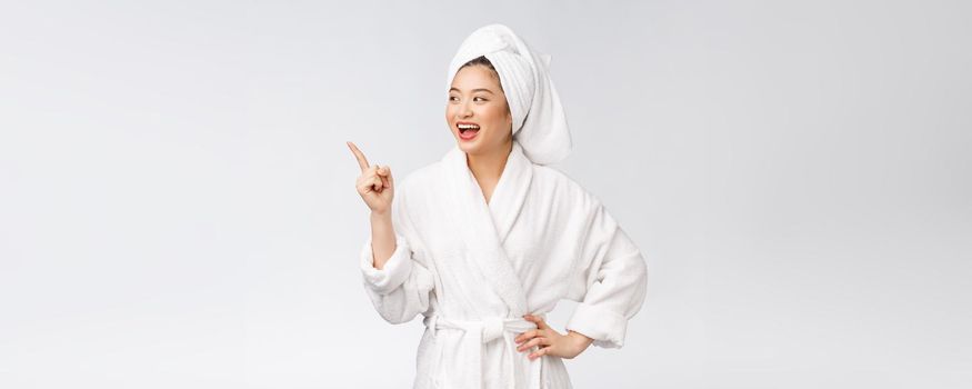 Beauty portrait of young woman showing and pointing finger to empty copy space, asian beauty in bathrobe