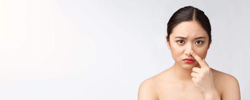 Face Skin Problem - young woman unhappy touch her skin isolated, concept for skin care, asian