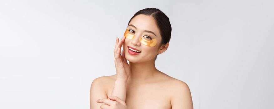 Asian beauty teenager woman care her skin with gold eye masks patches under eyes.