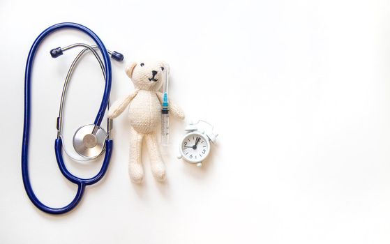 Teddy bear stethoscope and syringe isolate on a white background. Selective focus.