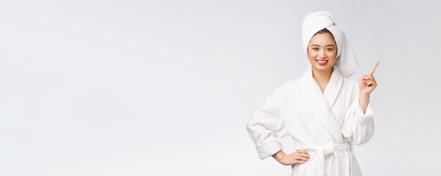 Beauty portrait of young woman showing and pointing finger to empty copy space, asian beauty in bathrobe