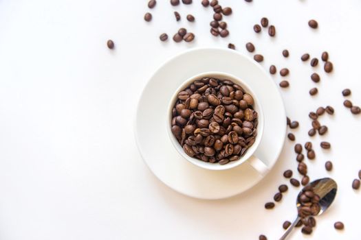 white cup and coffee beans on a white background. Selective focus.