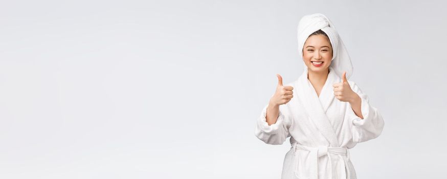 Beautiful asian woman perfect skin showing thumbs up isolated on white background