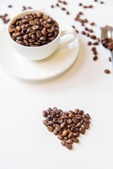 white cup and coffee beans on a white background. Selective focus.